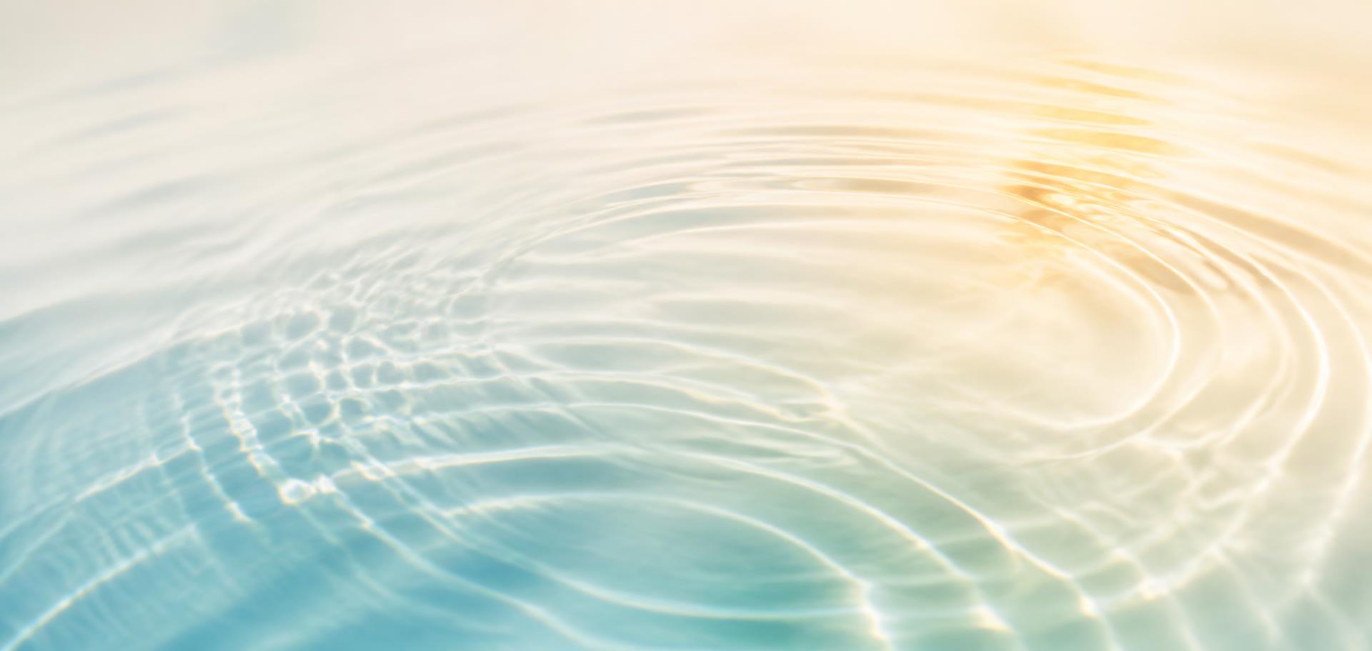 Sanfte Wasserwellen mit warmem Licht — Symbol für energetische Resonanz